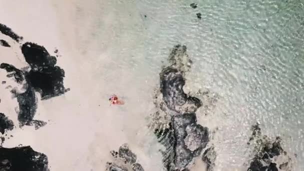 vista aérea de mujer joven que tiene baño de sol que relaja en el colchón inflable de lilo en la laguna tropical azul del océano
  - Metraje, vídeo