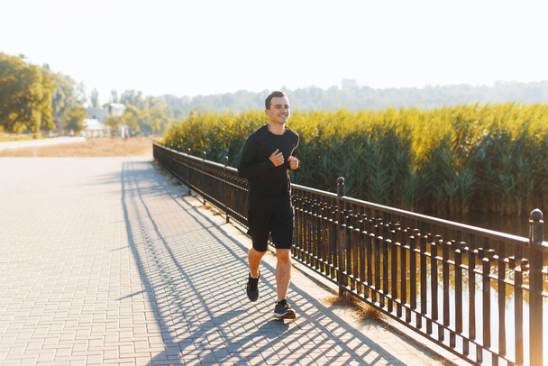Foto van iemand jonge man, Running Inn Park, op de ochtend zonlicht, sport concept - Foto, afbeelding