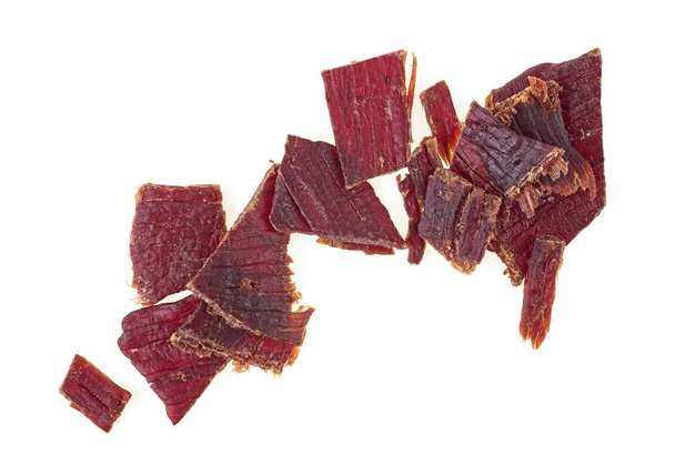 Beef jerky on a white white background, top view. - Foto, afbeelding