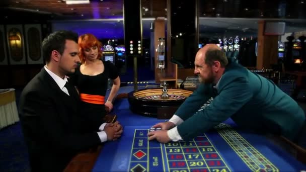mladý muž dostává vítězné čipy a dávat na jeho milenka a další kasino Worker - Záběry, video