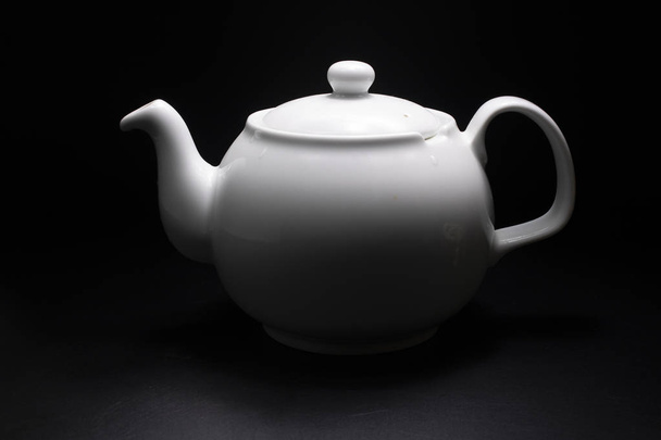 White porcelain teapot. Traditional design. Black background. - Photo, Image