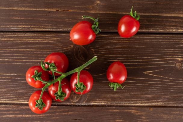 Červené třešňové rajče na hnědém dřevě - Fotografie, Obrázek