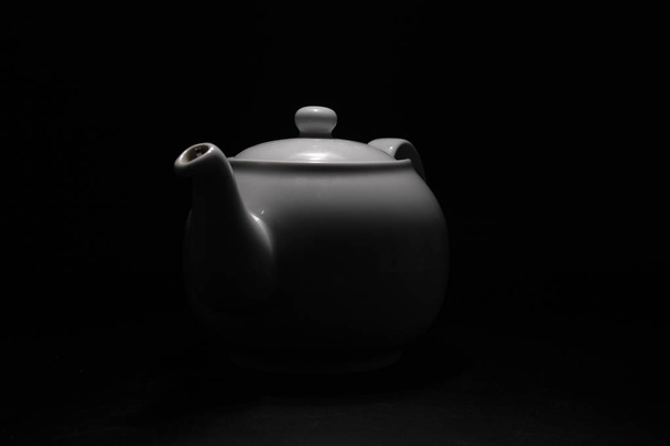 Белый фарфоровый чайник. Традиционный дизайн. Чёрный фон
. - Фото, изображение