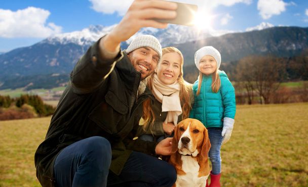 famiglia felice con cane che prende selfie in autunno
 - Foto, immagini