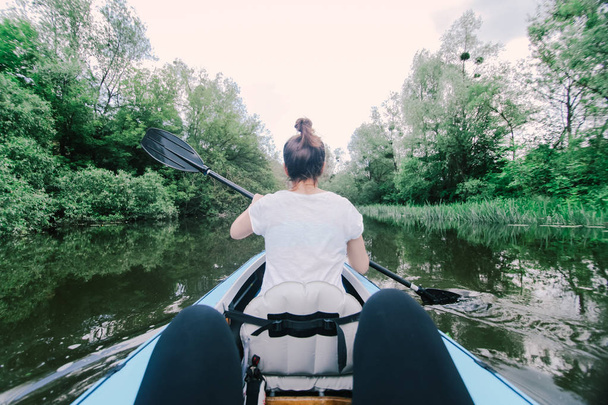Due persone galleggiano su una canoa sul fiume
. - Foto, immagini