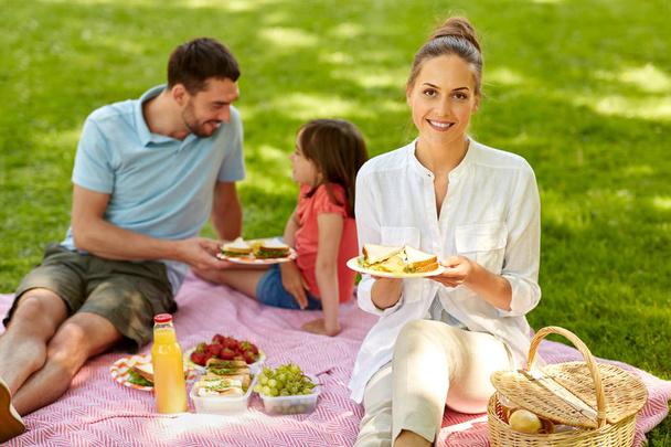 happy family having picnic at summer park - Fotoğraf, Görsel