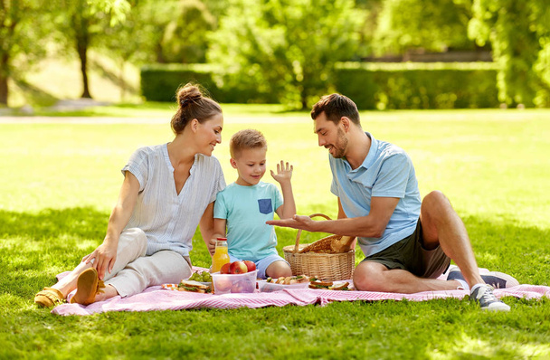 happy family having picnic at summer park - Fotó, kép