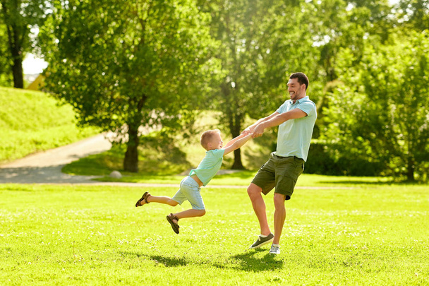happy father and son having fun at summer park - Zdjęcie, obraz