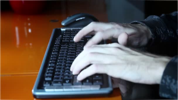 shot van een mans handen te typen op een toetsenbord van de computer - Video