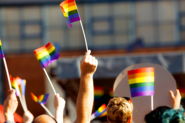 Communauté de fierté lors d'un défilé avec les mains levées et le drapeau LGBT
  - Photo, image