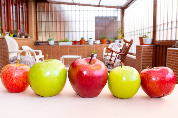 Zelená a červená jablka rozmezená v řadě v zahradě - Fotografie, Obrázek
