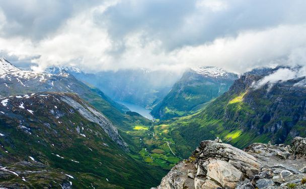 Blick auf den Geiranger-Fjord mit grünem Tal umgeben von Bergen - Foto, Bild