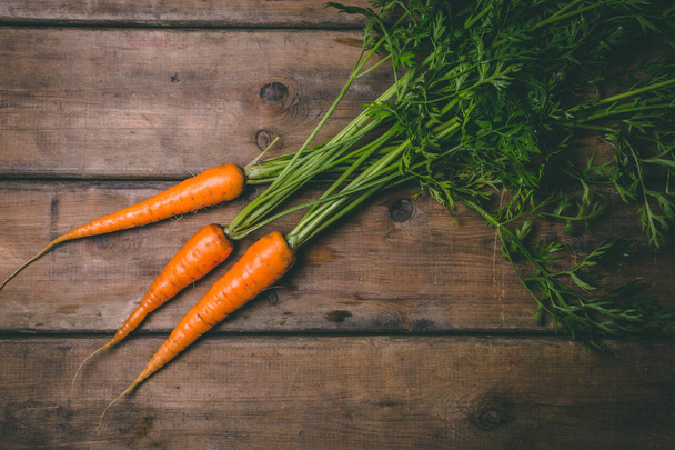 Fresh tasty carrots on a wooden rustic table. Healthy food. Vege - Fotoğraf, Görsel