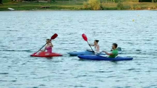 Junge Leute paddeln auf dem See in Richtung Kamera - Filmmaterial, Video