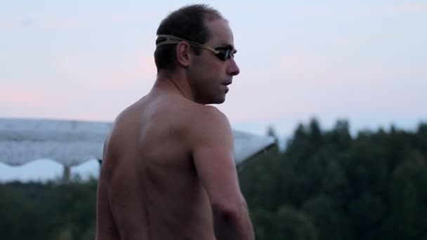 Mann macht sich bereit zum Schwimmen im See - Filmmaterial, Video