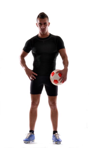 γυμναστήριο ποδοσφαιριστής και μια μπάλα ποδοσφαίρου. - Φωτογραφία, εικόνα