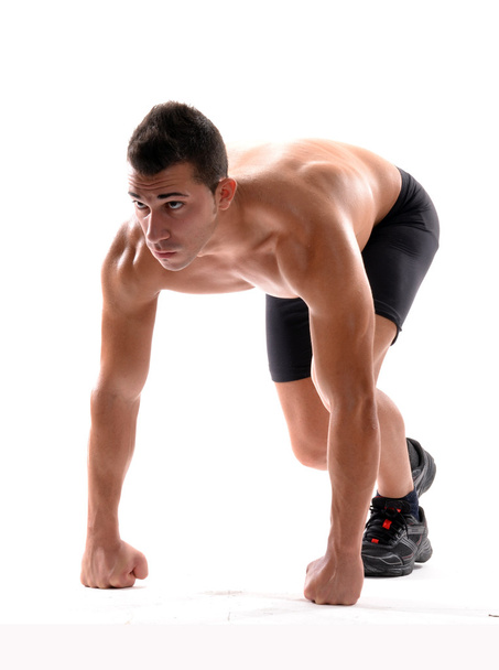 Healthy and fitness man on running start position on white background. - Valokuva, kuva