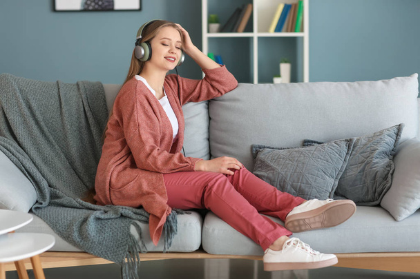 Beautiful young woman listening to music at home - Fotografie, Obrázek