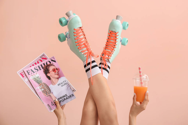 Woman in vintage roller skates, with fashion magazines and juice on color background - Foto, afbeelding