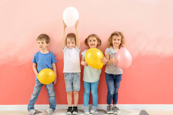 Cute little children with air balloons near color wall - Foto, imagen