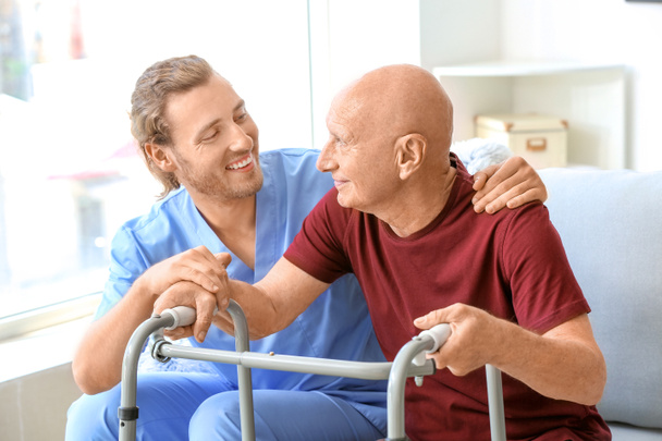 Elderly man with caregiver in nursing home - Foto, imagen