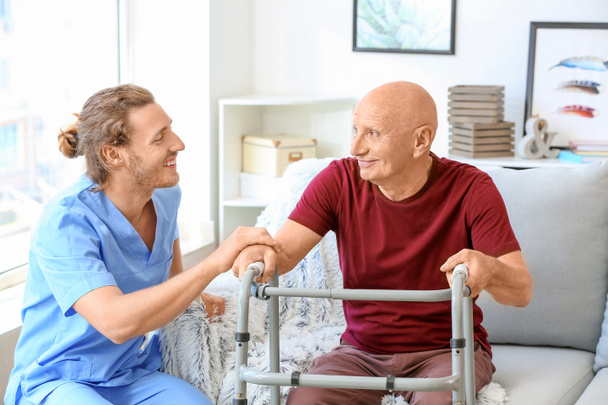 Elderly man with caregiver in nursing home - Fotó, kép