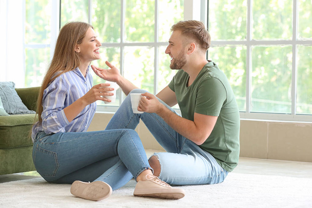 Portrait of happy young couple drinking coffee at home - Fotoğraf, Görsel