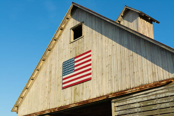 Antiguo granero de madera con bandera americana
 - Foto, imagen