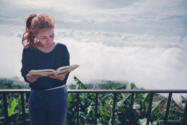 Vrouwen ontspannen lezen ochtend boek goed weer hemel mist. Op de bergen, de ochtend sfeer. - Foto, afbeelding