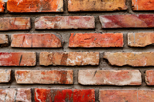 Texture d'un mur de briques avec des fissures et des rayures qui peuvent être utilisées comme fond - Photo, image