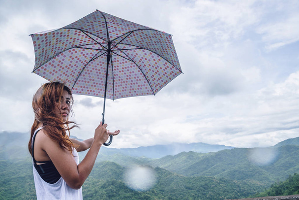 Οι ασιατικές γυναίκες ταξιδεύουν χαλαρώστε στις διακοπές. Οι γυναίκες στάθηκαν σε ομπρέλες βροχής στο βουνό. Κατά τη διάρκεια της εποχής των βροχών. Ταϊλάνδη - Φωτογραφία, εικόνα