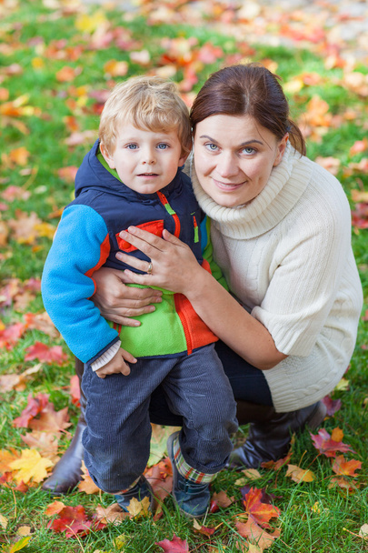Little toddler boy and young mother in the autumn park - Foto, Bild