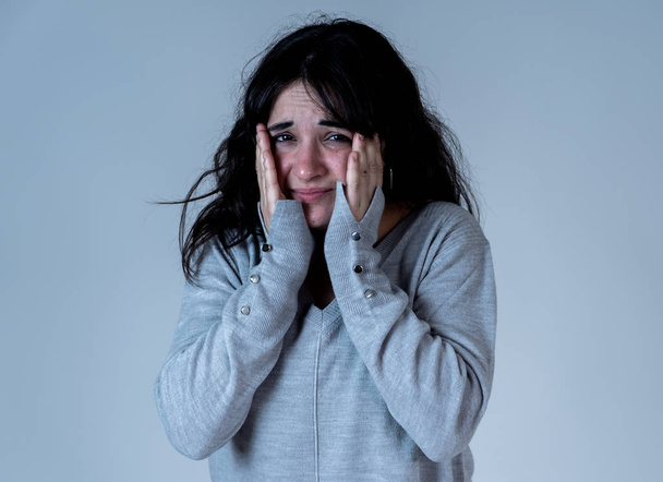 Close up portrait of scared and shocked young woman receiving bad news and looking with fear in her eyes at something scary. People and Human expressions and emotions concept. Studio shot. - Foto, Imagen