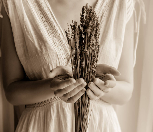 Frau in weißem Kleid hält Lavendel am Fenster - Foto, Bild