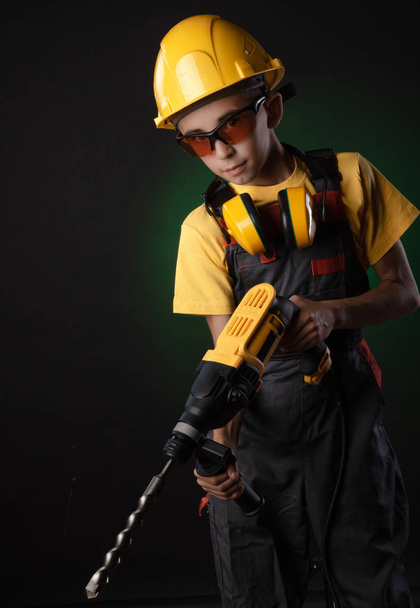 enfant le costume de constructeur posant avec un outil de travail
 - Photo, image