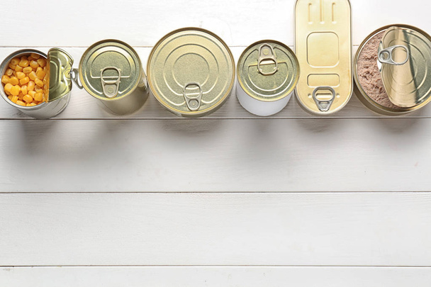 жестяные банки с пищей на белом деревянном фоне
 - Фото, изображение