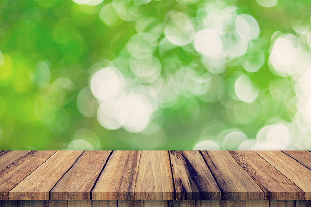 Пустой деревянный стол и абстрактные размытые зеленые листья боке
 - Фото, изображение