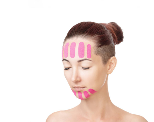 Woman with kinesio tapes on forehead and chin, beauty procedure. - Фото, изображение