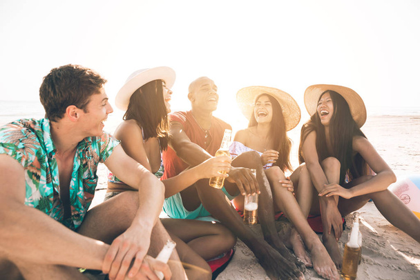 Group of friends spending time on the beach together celebrating - Photo, image