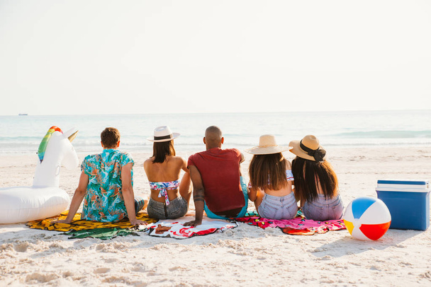 Group of friends spending time on the beach together celebrating - Фото, изображение