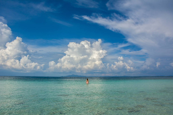 Mujer joven en aguas turquesas bajo el cielo nublado, mar de Andamán
 - Foto, Imagen