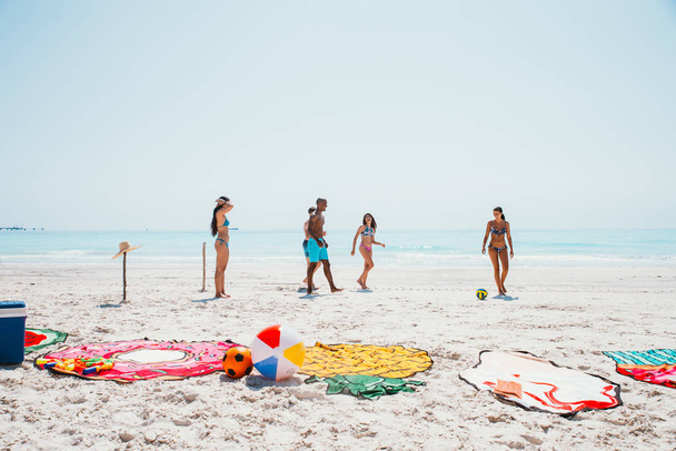 Group of friends spending time on the beach together celebrating - 写真・画像