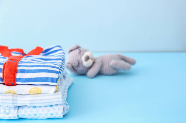 Stack of baby clothes on color background - Photo, Image