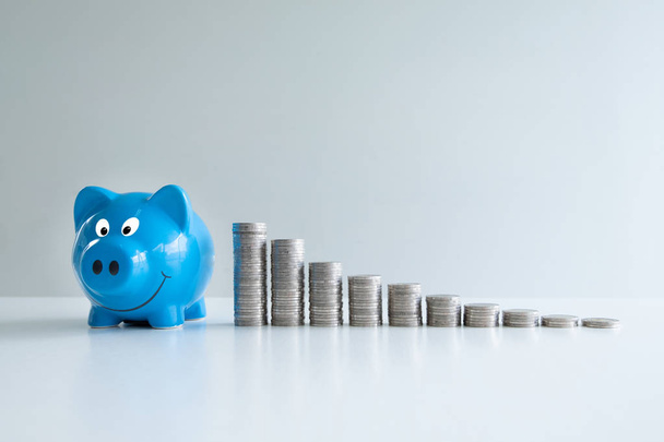 blaues Sparschwein mit Münzen-Balkendiagramm, Steigerung des Geschäftswachstums zum Erfolg und Sparen für das Rentenkonzept - Foto, Bild