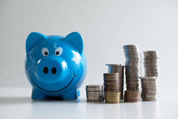 niebieski Skarbonka banku z monet stos, krok do wzrostu biznesu do sukcesu i oszczędności na emeryturę koncepcji - Zdjęcie, obraz