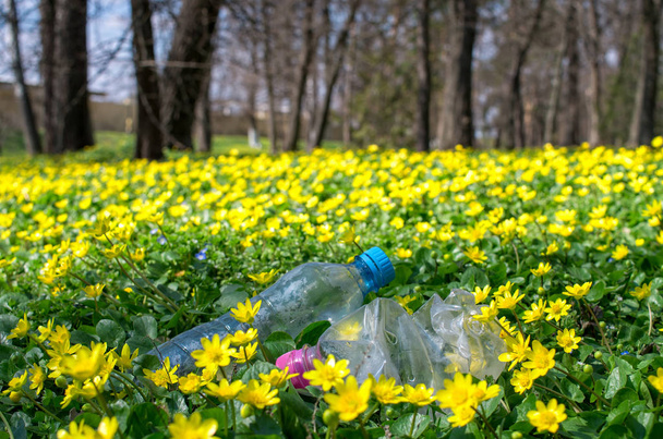 garrafas de plástico descartadas e embalagens na grama do parque
 - Foto, Imagem