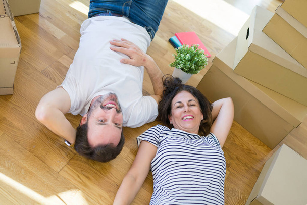 Romantisches Paar mittleren Alters auf dem Boden liegend, lächelnd ha - Foto, Bild