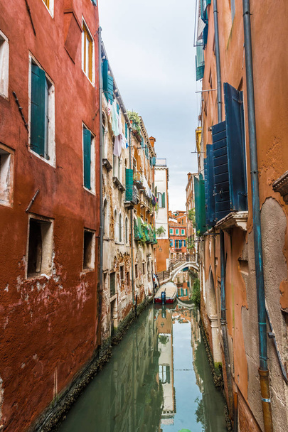 Old houses, washed by sea waters, stand along narrow canals in the heart of ancient Venice. - Photo, image