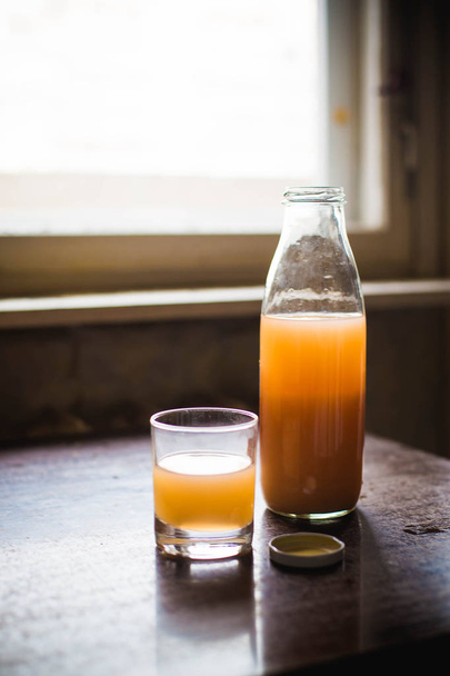 Freshly squeezed orange juice in a glass bottle - Foto, imagen