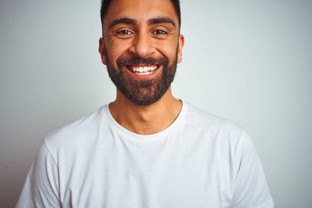 Jeune homme indien portant t-shirt debout sur fond blanc isolé avec un sourire heureux et cool sur le visage. Personne chanceuse
. - Photo, image